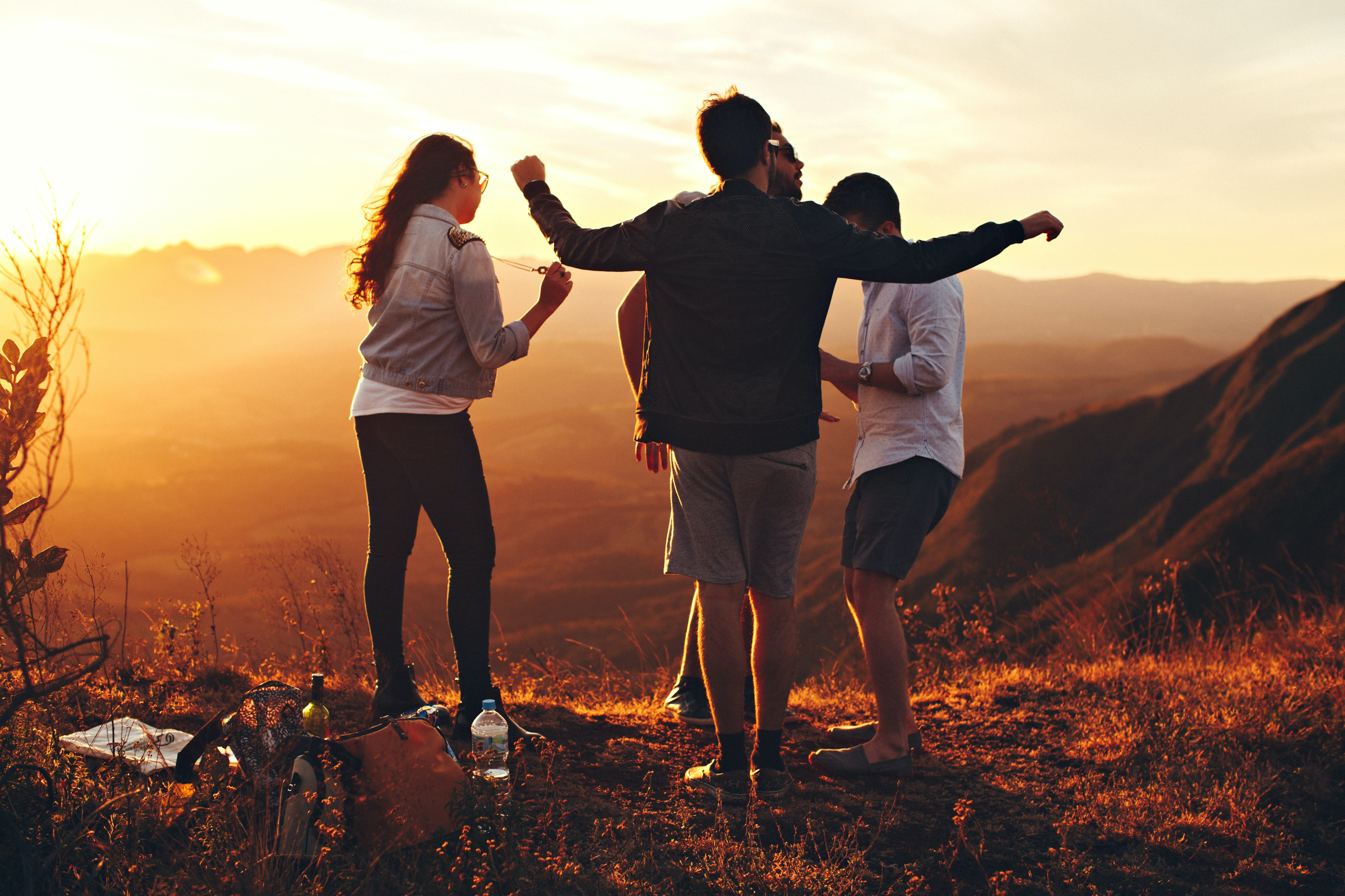 Friends dance in sunny hilltops together as they go camping